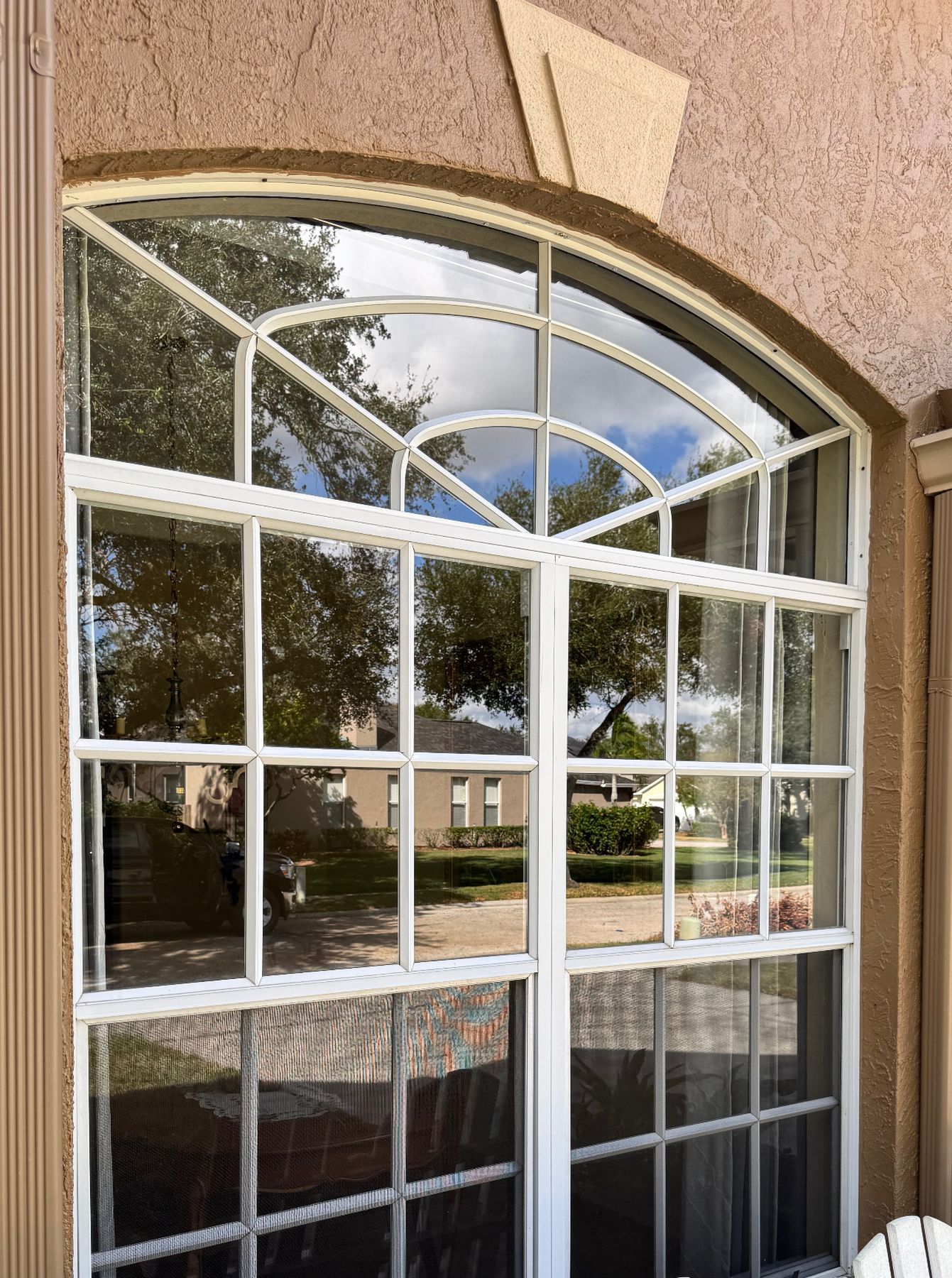 Large two-story arched window with white grid muntins